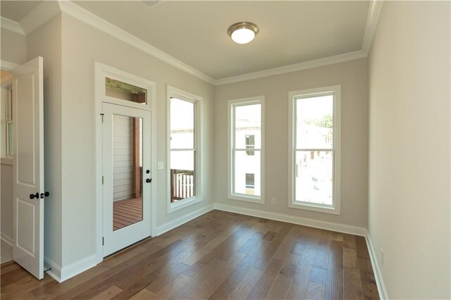 doorway with plenty of natural light, crown molding, and hardwood / wood-style floors