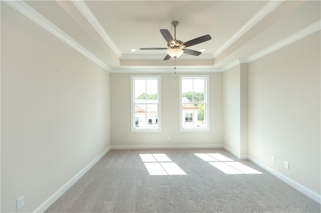 unfurnished room with light carpet, a tray ceiling, ornamental molding, and ceiling fan