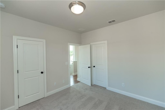 unfurnished bedroom featuring light carpet