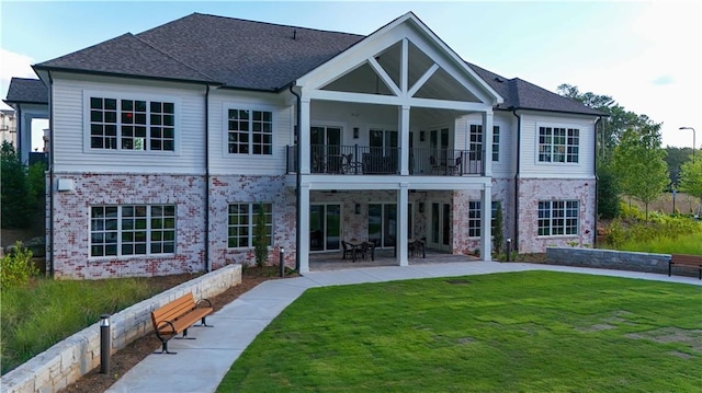 back of house with a balcony, a patio, and a yard