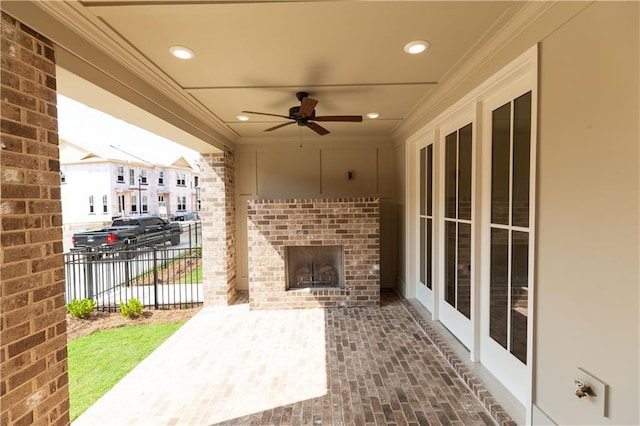 view of patio featuring an outdoor brick fireplace and ceiling fan