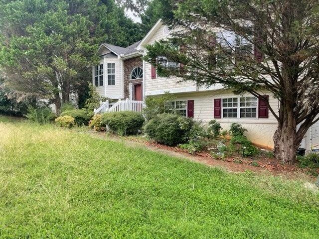 split foyer home featuring a front lawn