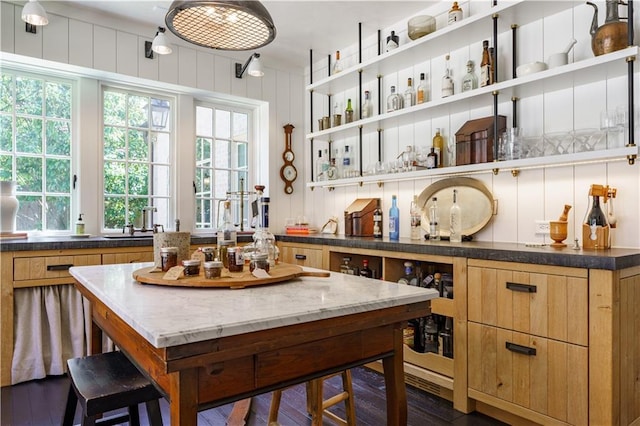 kitchen with open shelves, dark stone counters, and dark wood finished floors