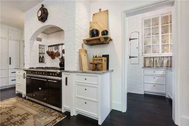 kitchen featuring dark wood-style flooring, white cabinets, open shelves, and range with two ovens