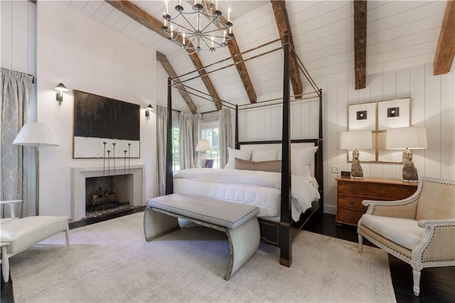 bedroom featuring a notable chandelier, a fireplace, and vaulted ceiling with beams