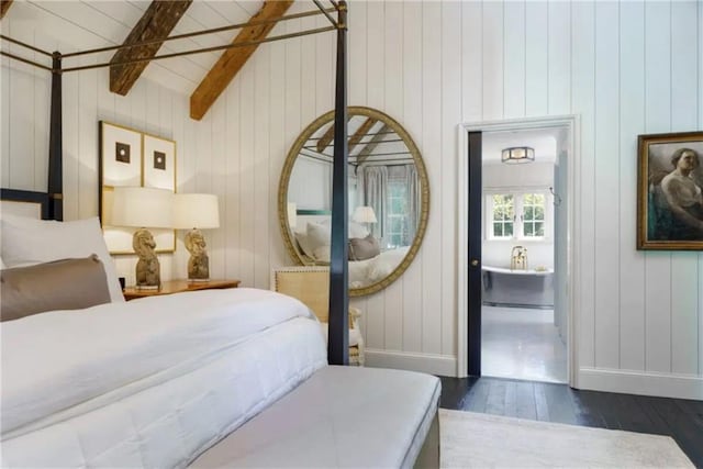 bedroom featuring dark wood finished floors, vaulted ceiling with beams, and baseboards