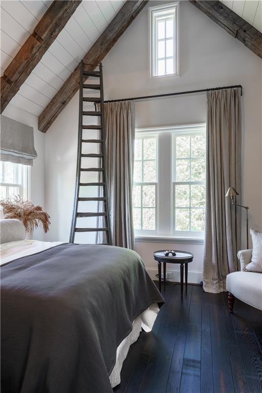 bedroom featuring multiple windows, wooden ceiling, lofted ceiling with beams, and hardwood / wood-style floors