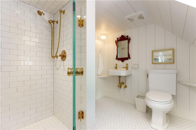 full bath featuring toilet, vaulted ceiling, and a tile shower