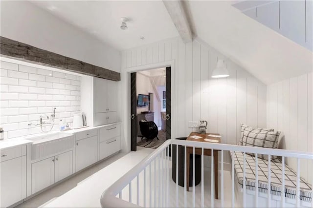 bedroom featuring vaulted ceiling with beams and a sink