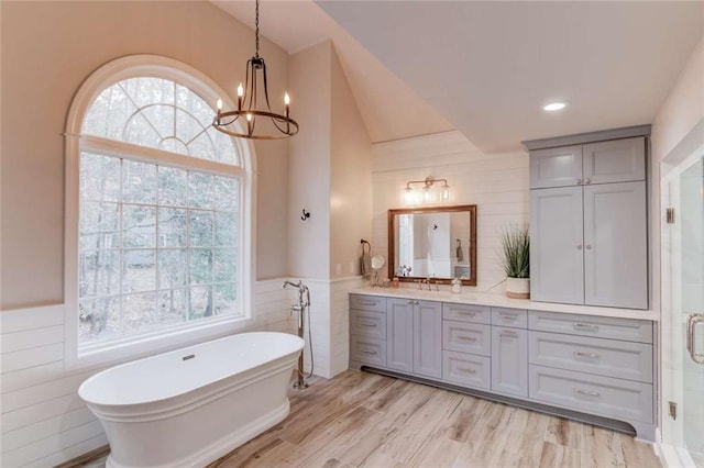 3000 The Springs Dr, Monroe, GA 30656 - full bathroom with tile walls, double vanity, a soaking tub, a chandelier, and a stall shower