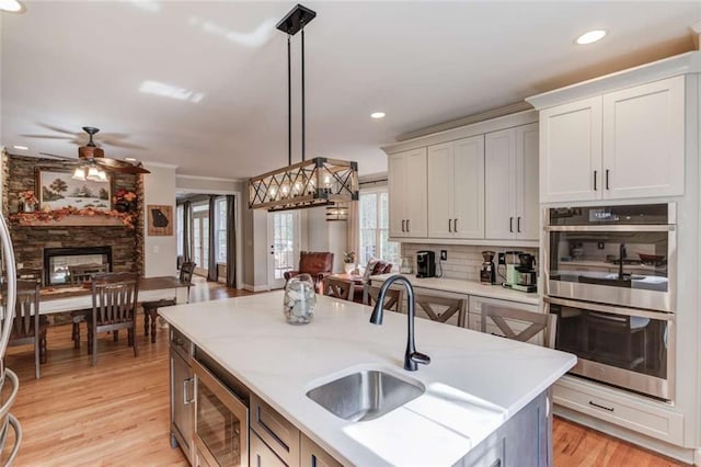 3000 The Springs Dr, Monroe, GA 30656 - kitchen with appliances with stainless steel finishes, a fireplace, a ceiling fan, decorative light fixtures, and backsplash