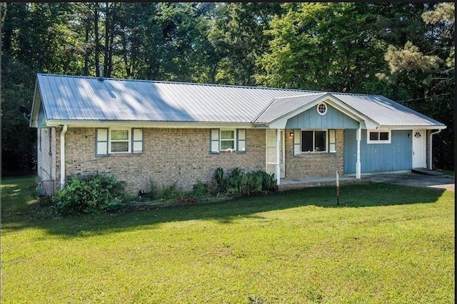 single story home with metal roof, brick siding, and a front yard