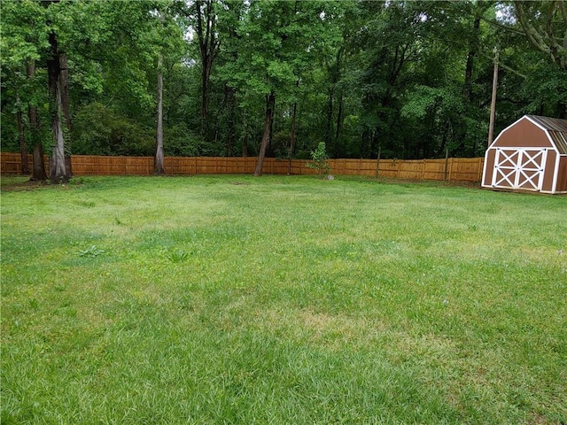 view of yard featuring a storage unit, an outbuilding, and fence