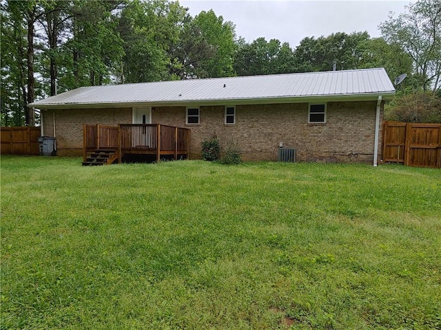 back of house featuring metal roof, central air condition unit, a wooden deck, and fence