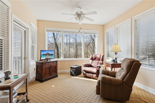 living area with ceiling fan and light colored carpet