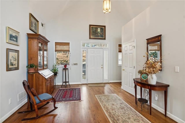 foyer featuring high vaulted ceiling and wood-type flooring