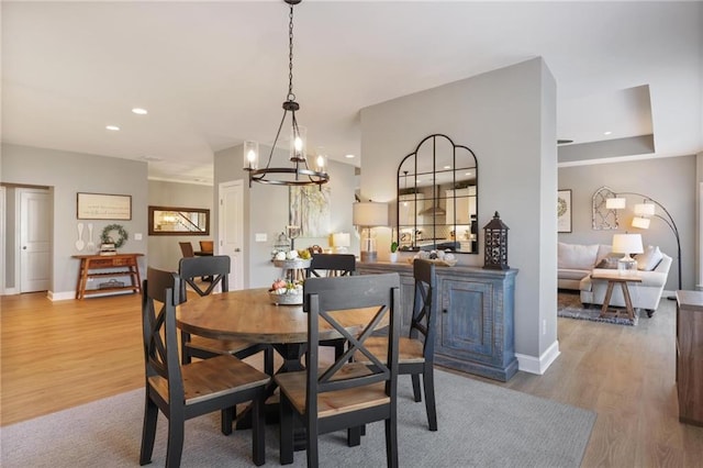 dining room with an inviting chandelier, recessed lighting, wood finished floors, and baseboards