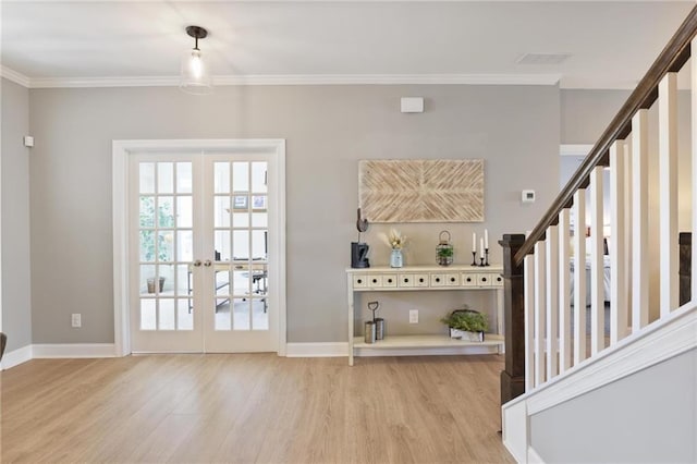 entryway with light wood-style flooring, stairs, crown molding, and baseboards