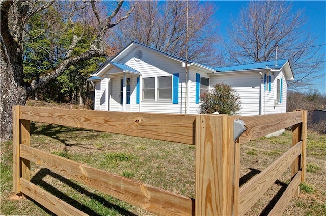 view of front of house with metal roof and fence