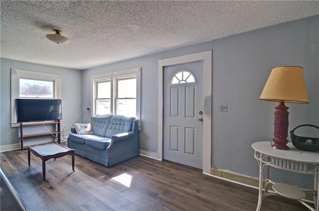 entrance foyer featuring a textured ceiling, baseboards, and wood finished floors