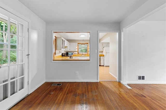 empty room with hardwood / wood-style flooring and sink