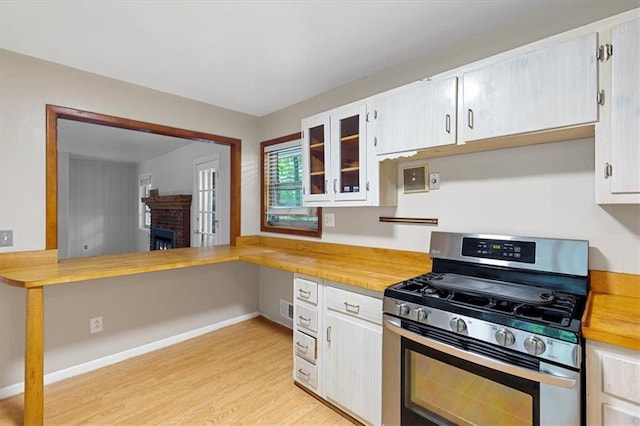 kitchen featuring gas stove, light hardwood / wood-style floors, and white cabinetry