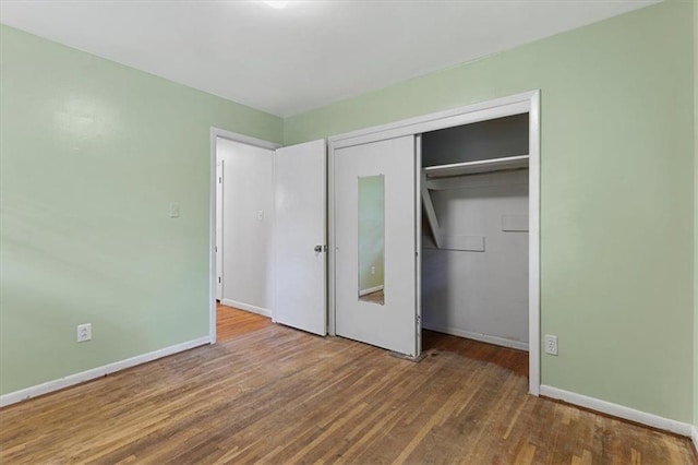 unfurnished bedroom with hardwood / wood-style floors and a closet