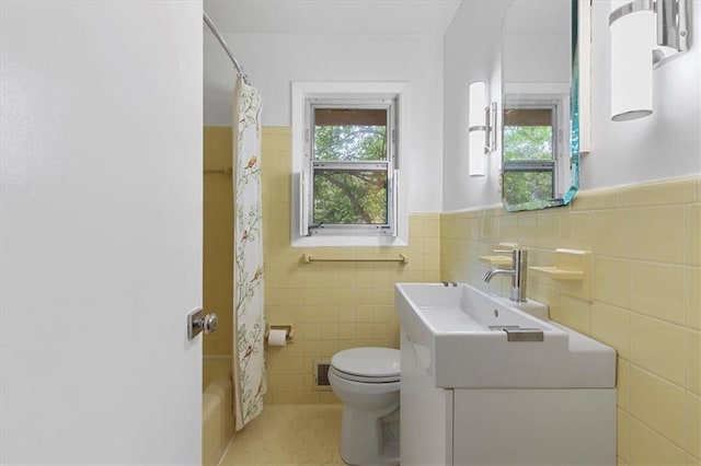 full bathroom featuring toilet, tile patterned floors, vanity, shower / bathtub combination with curtain, and tile walls