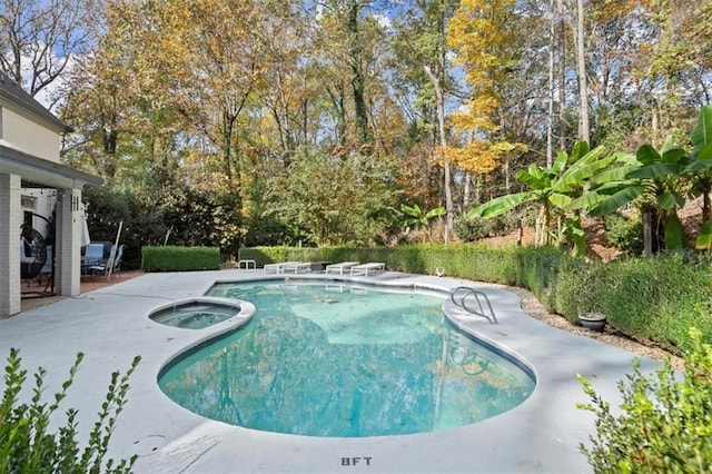 view of swimming pool with an in ground hot tub and a patio area