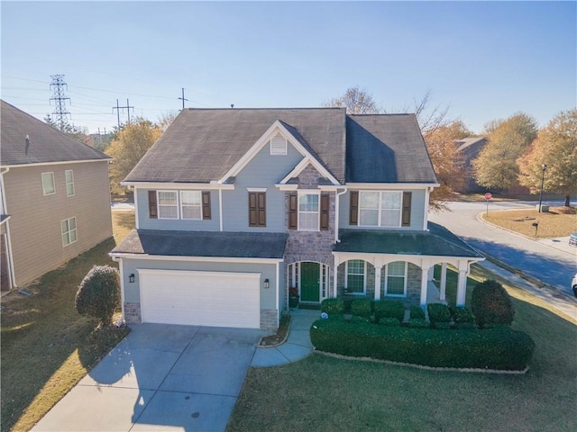 view of front of property with a front yard, a porch, and a garage