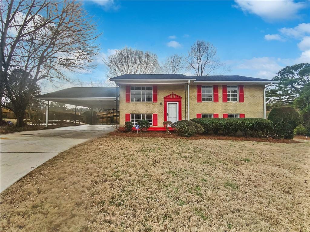 split foyer home featuring a front lawn and a carport