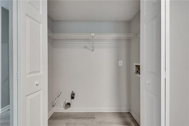 clothes washing area featuring washer hookup, light wood-type flooring, and a textured ceiling