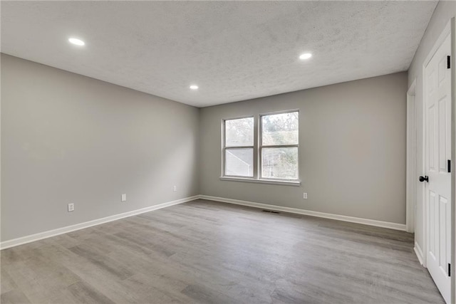 unfurnished bedroom featuring a textured ceiling and light hardwood / wood-style floors