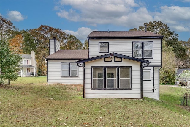 rear view of house featuring a yard