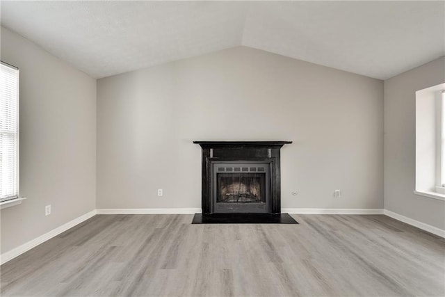 unfurnished living room featuring a wealth of natural light, light hardwood / wood-style flooring, and lofted ceiling