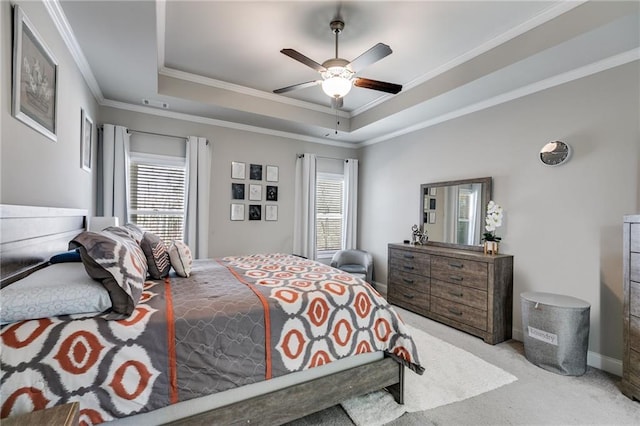 carpeted bedroom featuring multiple windows, a tray ceiling, and crown molding