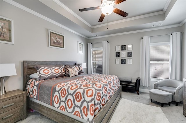 bedroom with ornamental molding, light carpet, ceiling fan, and a raised ceiling