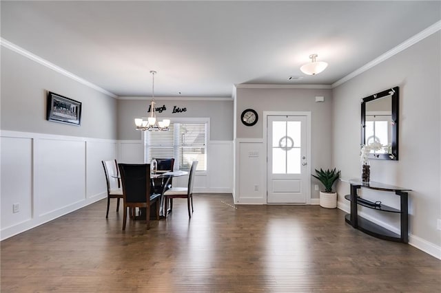 dining room featuring an inviting chandelier, crown molding, and dark hardwood / wood-style floors