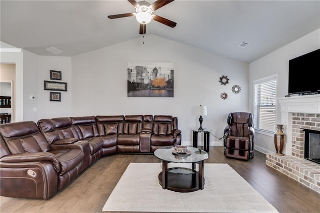 living room featuring a fireplace, ceiling fan, vaulted ceiling, and hardwood / wood-style flooring