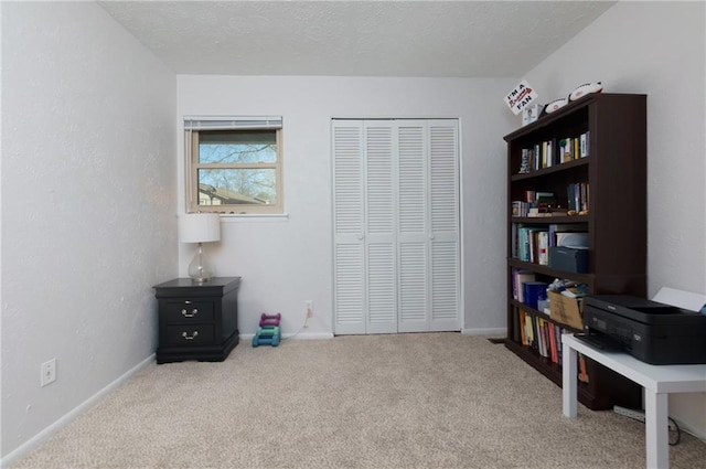 interior space featuring a textured ceiling, carpet, and baseboards