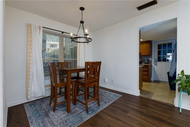 dining room with baseboards, visible vents, dark wood finished floors, and a chandelier