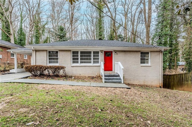 ranch-style house with brick siding, fence, and a front lawn