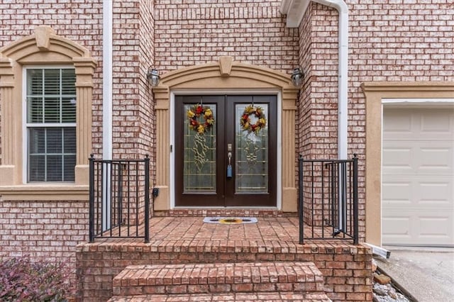 property entrance featuring brick siding and an attached garage