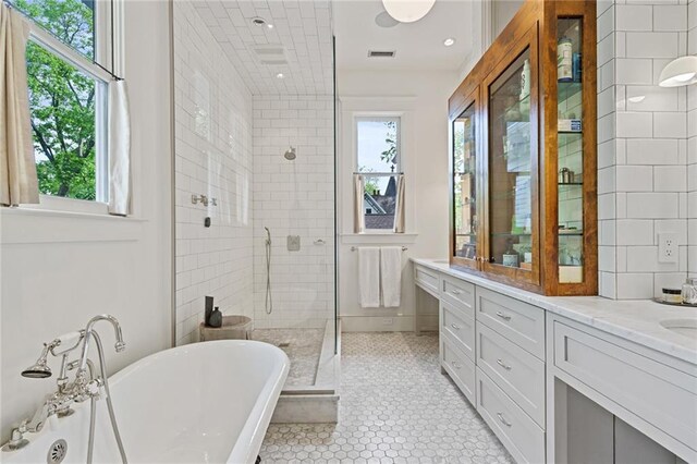 bathroom featuring visible vents, plenty of natural light, vanity, and a shower stall