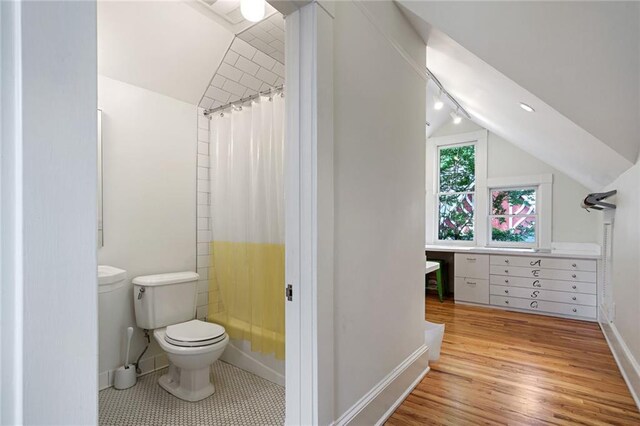 bathroom featuring baseboards, vaulted ceiling, toilet, and wood finished floors