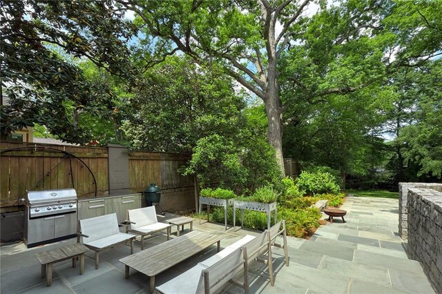 view of patio featuring fence, grilling area, and an outdoor hangout area