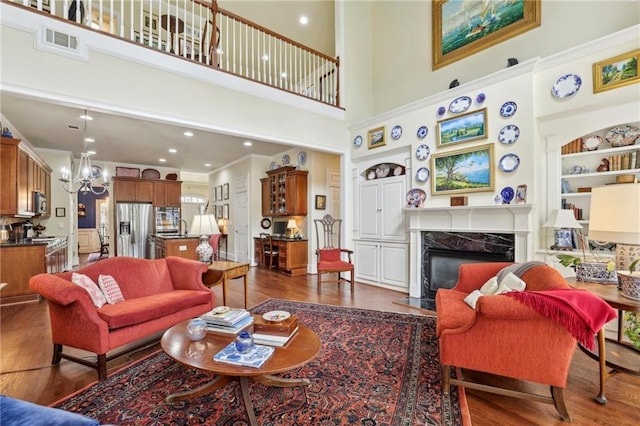 6259 Spalding Dr, Peachtree Corners, GA 30092 - living area featuring a fireplace, dark wood-style flooring, a chandelier, a towering ceiling, and recessed lighting