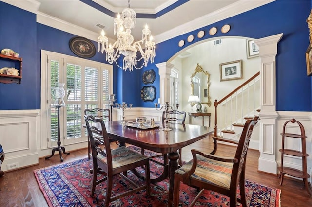 6259 Spalding Dr, Peachtree Corners, GA 30092 - dining area featuring wainscoting, a decorative wall, a chandelier, wood finished floors, and arched walkways