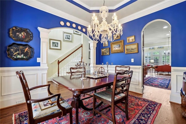 6259 Spalding Dr, Peachtree Corners, GA 30092 - dining room featuring arched walkways, stairs, a wainscoted wall, crown molding, and wood finished floors