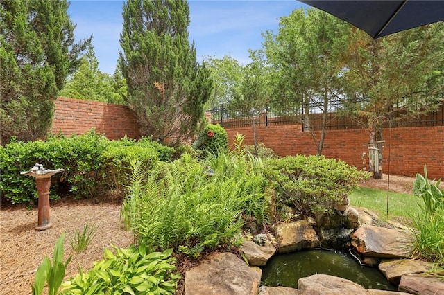6259 Spalding Dr, Peachtree Corners, GA 30092 - view of yard featuring fence and a garden pond